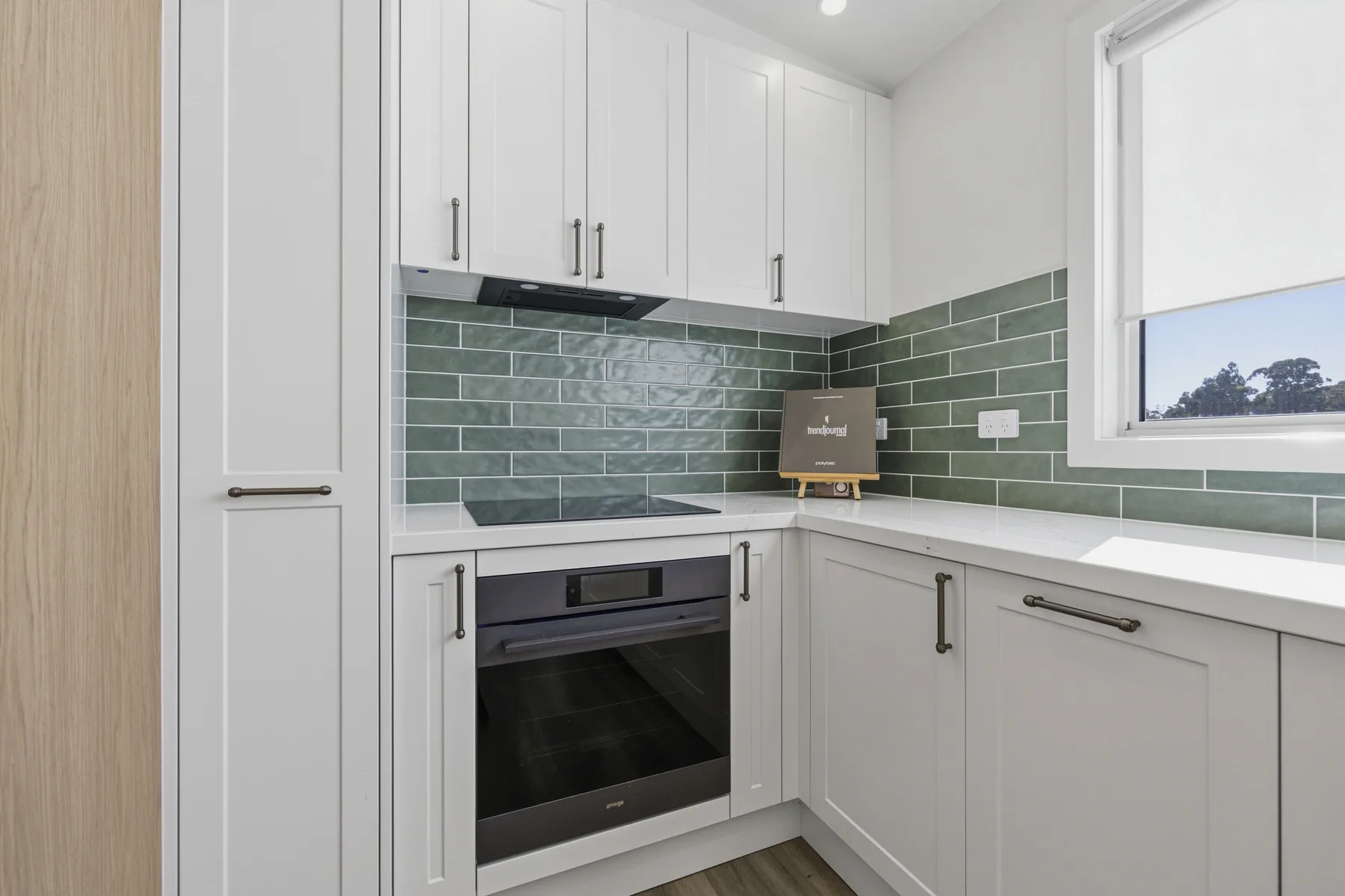 White shaker kitchen display with green tile splashback at the Kitchen Wizard Ballarat showroom